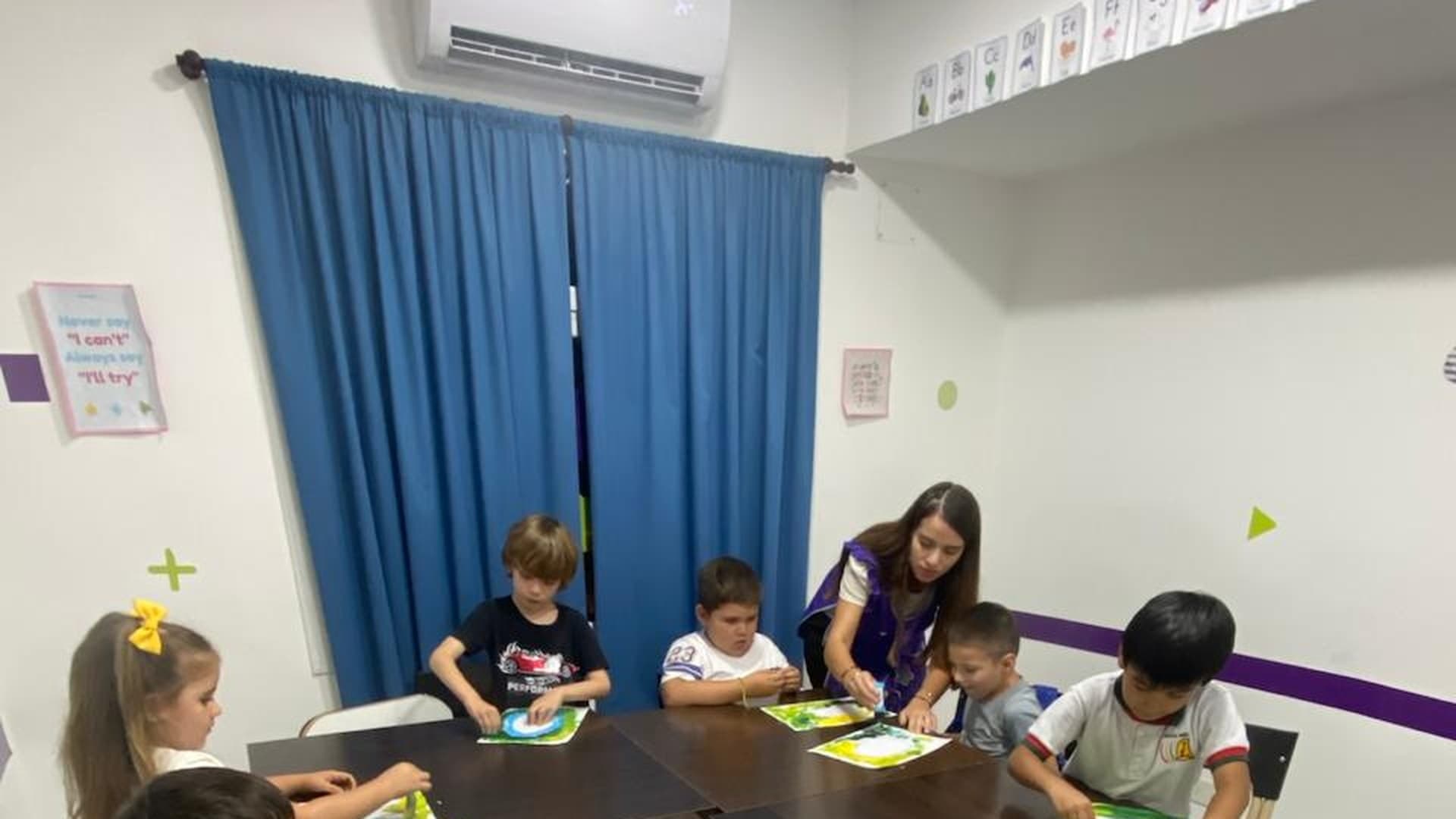Docente interactuando con alumnos en un aula moderna del instituto